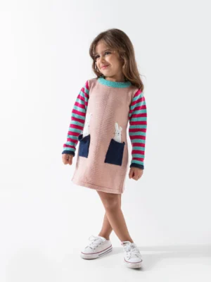 فستان تريكو بناتي شتوي وردي. يتميز بأكمام مخططة وجيوب عليها أرنب.