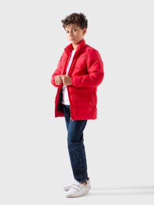 جاكيت أولادي شتوي منفوخ أحمر. قصة طويلة على شكل باركا بياقة عالية وجيوب كبيرة.